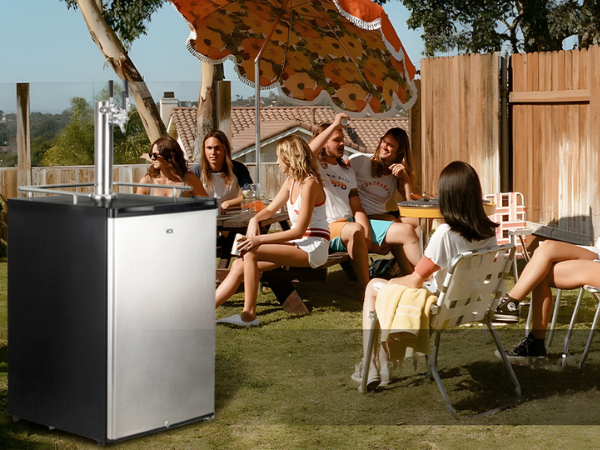 Front view of a camping site featuring the 6.53 Cu Ft Outdoor Kegerator Stainless Steel Refrigerator 230 Cans, positioned next to a group of people having a cheerful chat