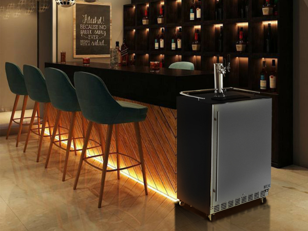 Side view of a bar setup with a 6.04 Cu Ft Undercounter Outdoor Refrigerator Kegerator installed beside the table. In the background is a wine shelf displaying various bottles of wine