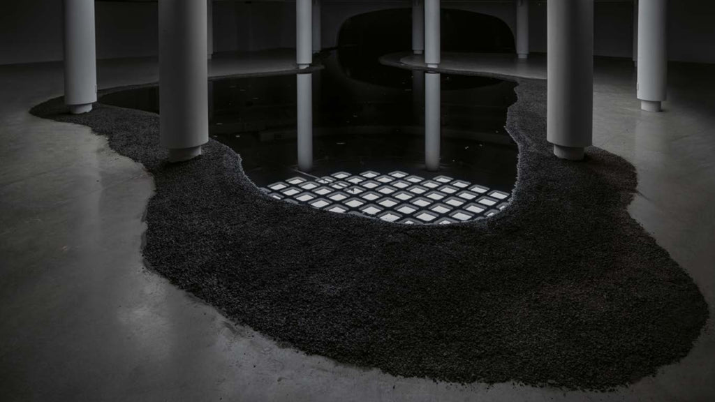 Charles Stankievech, The Dark Side of the Sun, 2023. 15,000 litre reservoir, crude oil, bacteria (Alcanivorax Borkumensis), water, CO2, Rundle rock, geomembrane, submersible speakers playing infrasound. Photo Courtesy: Studio Stankievech