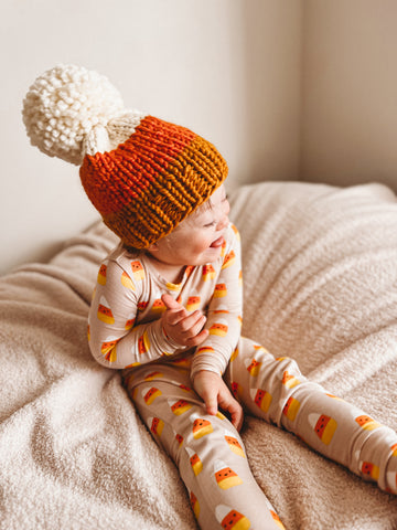 toddler boy wearing candy corn hat and 2 piece set