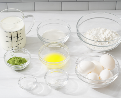 Ingredients to prepare a matcha mille crepe cake with fresh strawberries