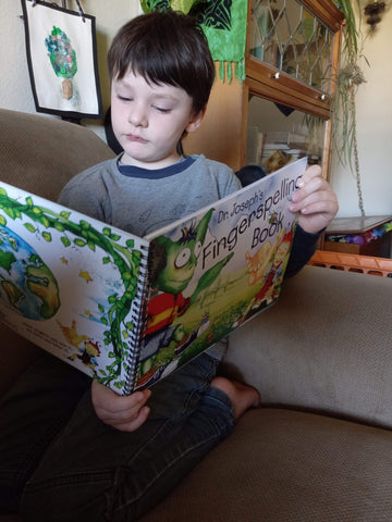Pre-schooler looks at Dr. Joseph's Fingerspelling Book