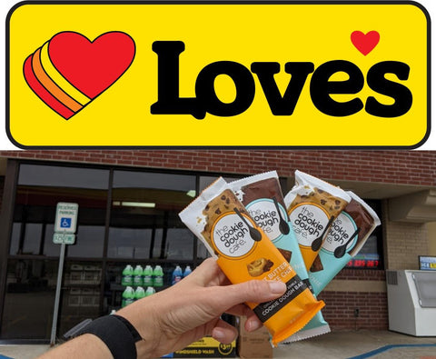 Hand holding Cookie Dough Café Bars in front of a Love's gas station