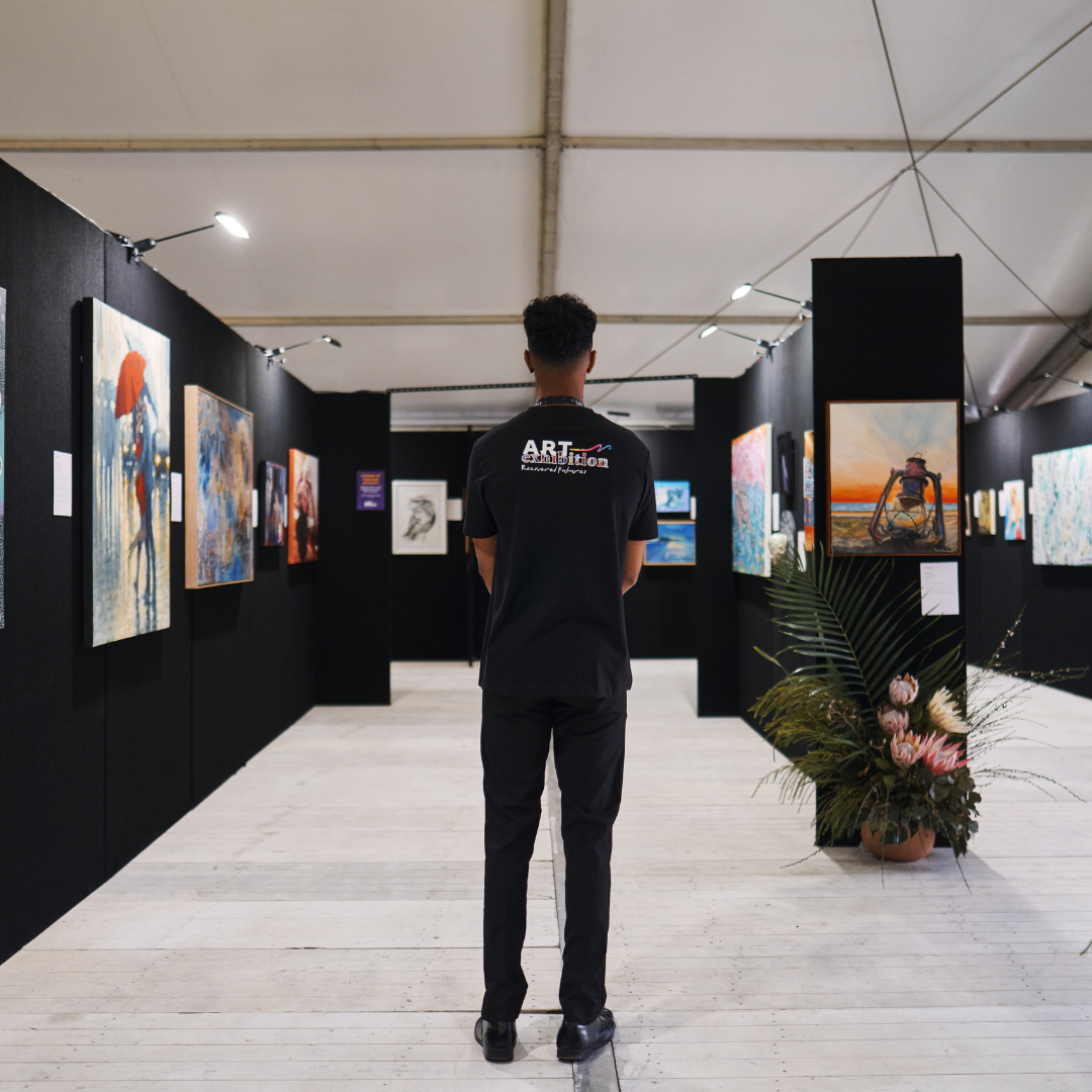 Person standing in an aisle looking at artwork