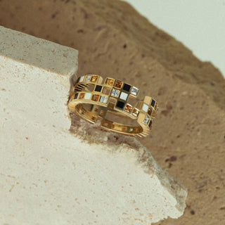 ifestyle image of statement Chichi ring by EDXU in recycled 18ct yellow gold with orange, yellow, and black gemstones