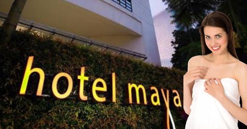 Woman wearing white towel in front of Hotel Maya, Kuala Lumpur 
