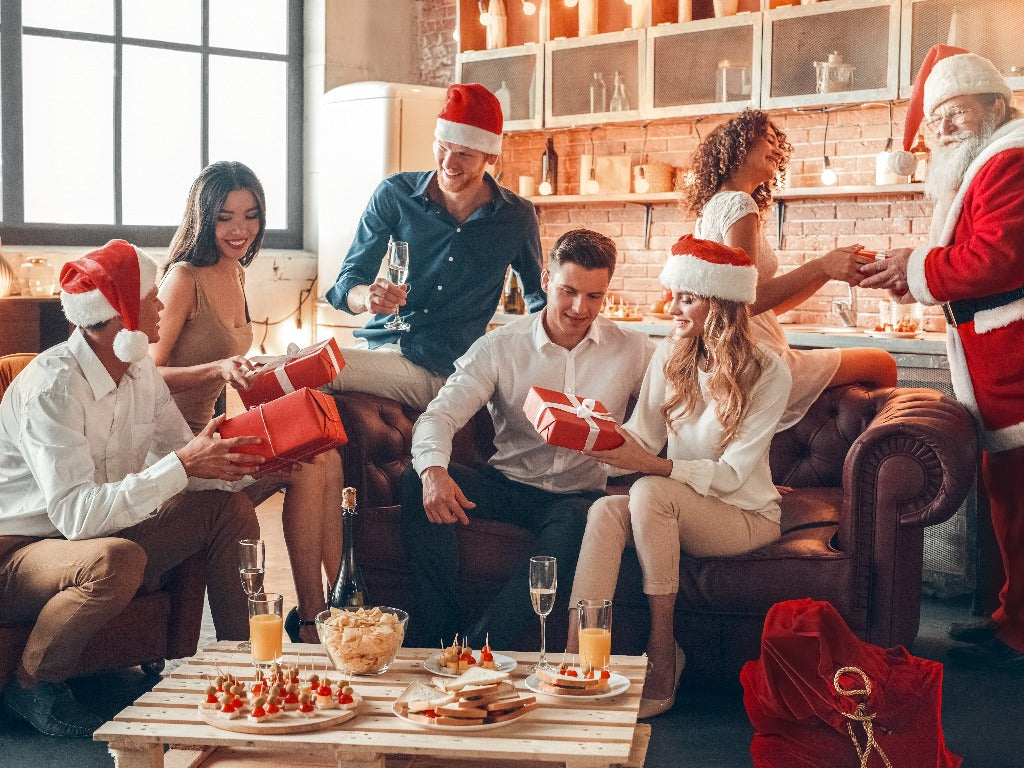 couples exchanging gifts from santa at christmas party