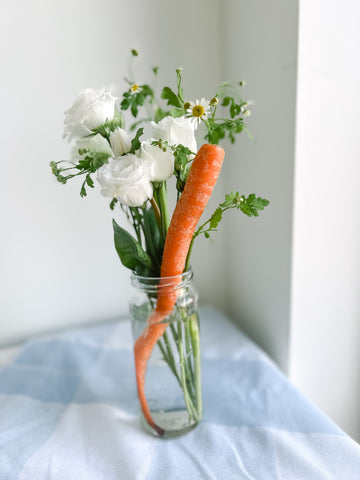 carrot flower centerpiece on gingham tablecloth