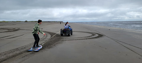 Owen sand boarding behind a four wheeler