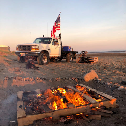 Alaskan bonfire with white truck on Bristol Bay beach