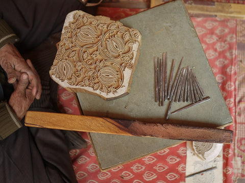 Block making tools and artisan's hand in a frame