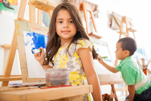 Little girl. painting at easel