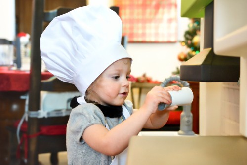 Kid dressed as a chef pretend cooking