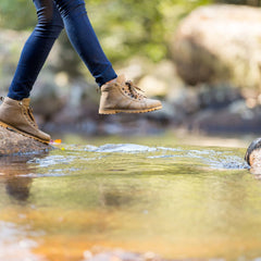 Hiker stepping over creek