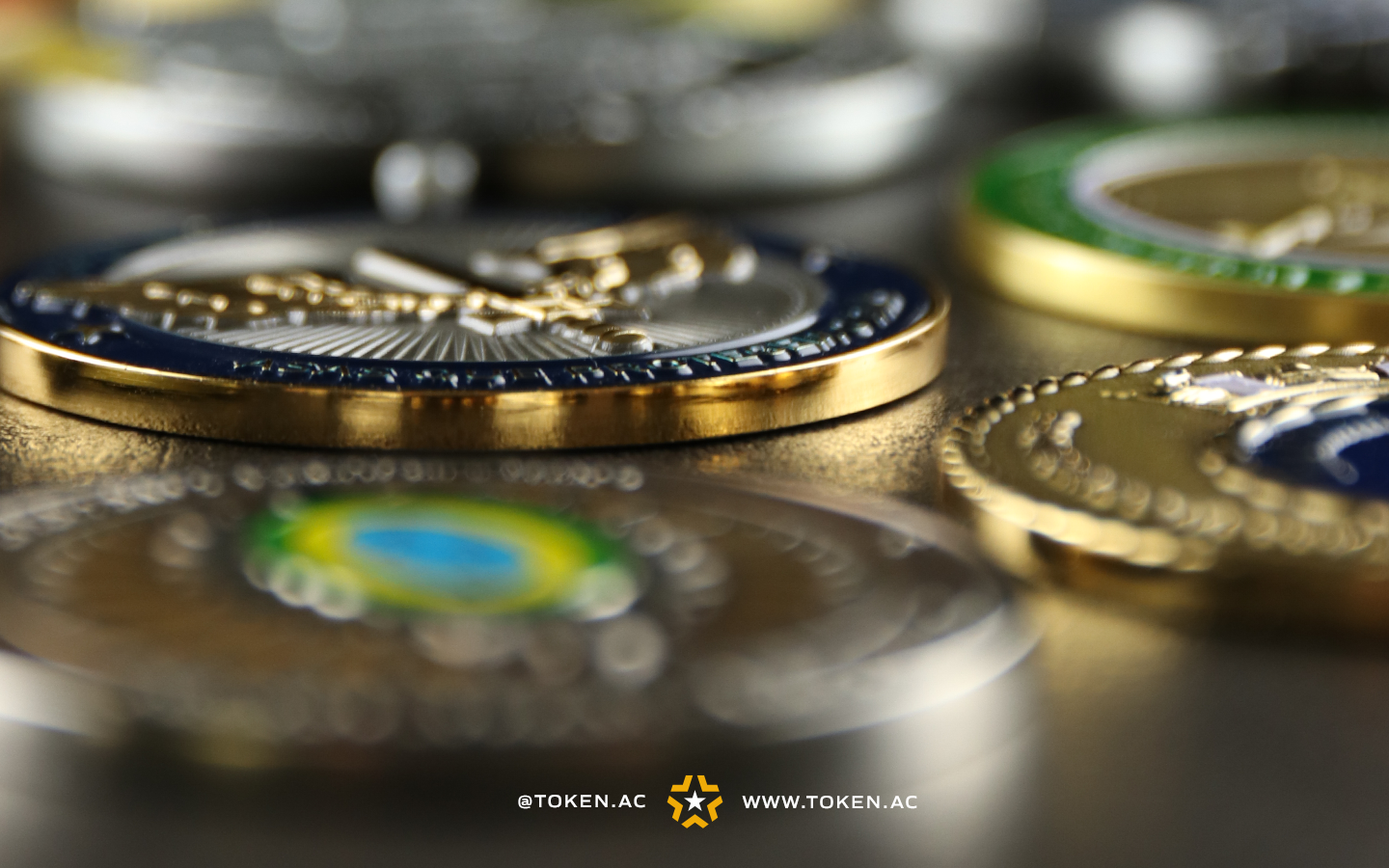 Challenge coins prateadas e douradas das forças armadas do Brasil sobre uma mesa.