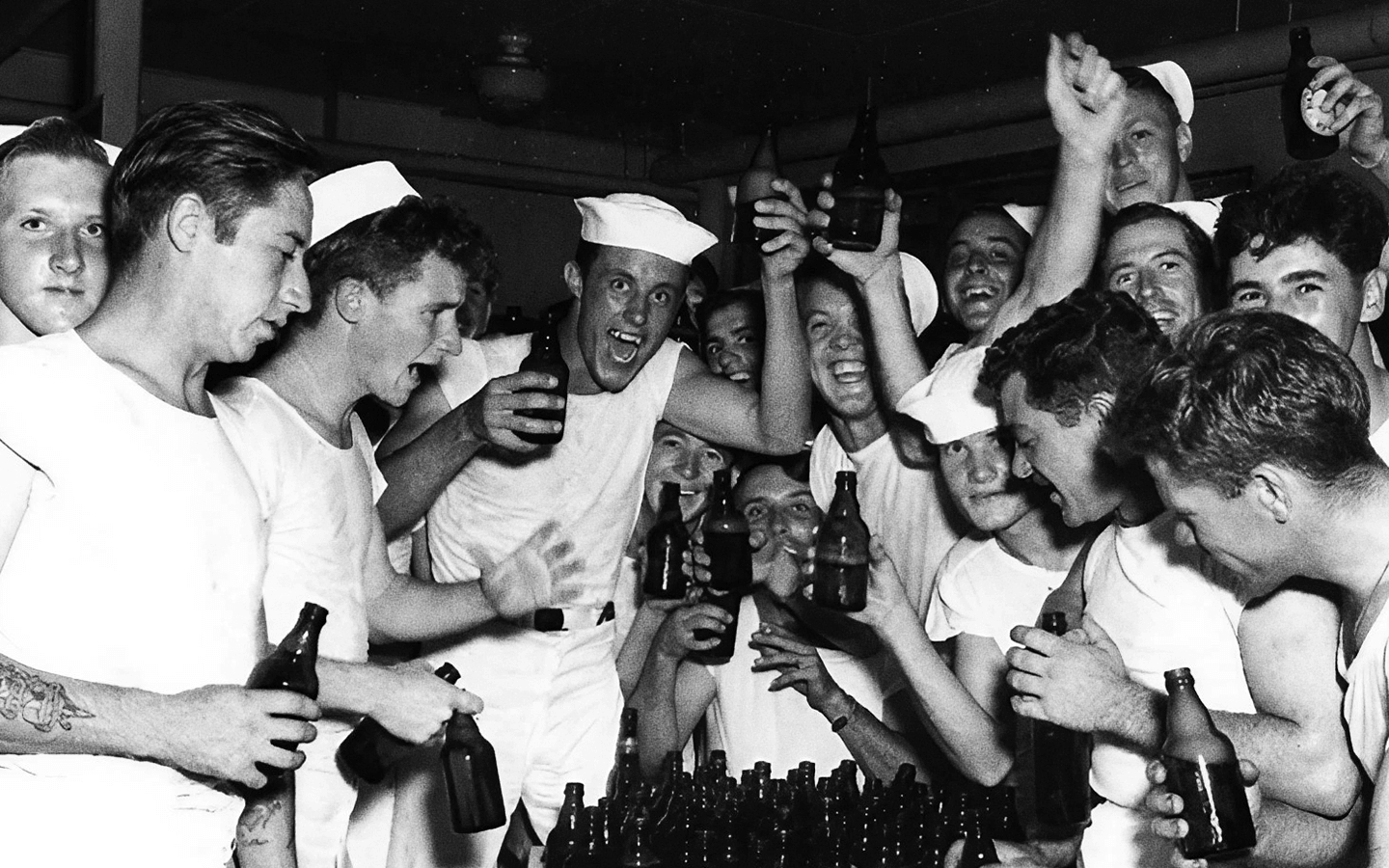 Soldados comemoram em um bar segurando bebidas e expressões felizes.
