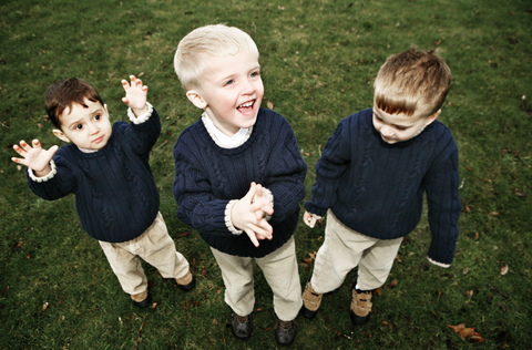 Three children wearing matching jumpers and pants