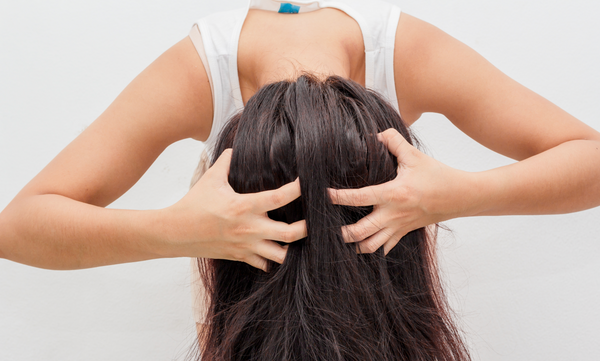 Woman with her head flipped over shaking out dandruff