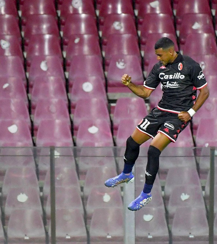 Bari soccer star Walid Cheddira jumping in the air fist pumping 