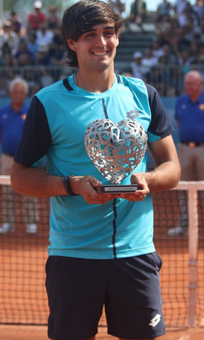  Juan Bautista Torres holding a trophy. 