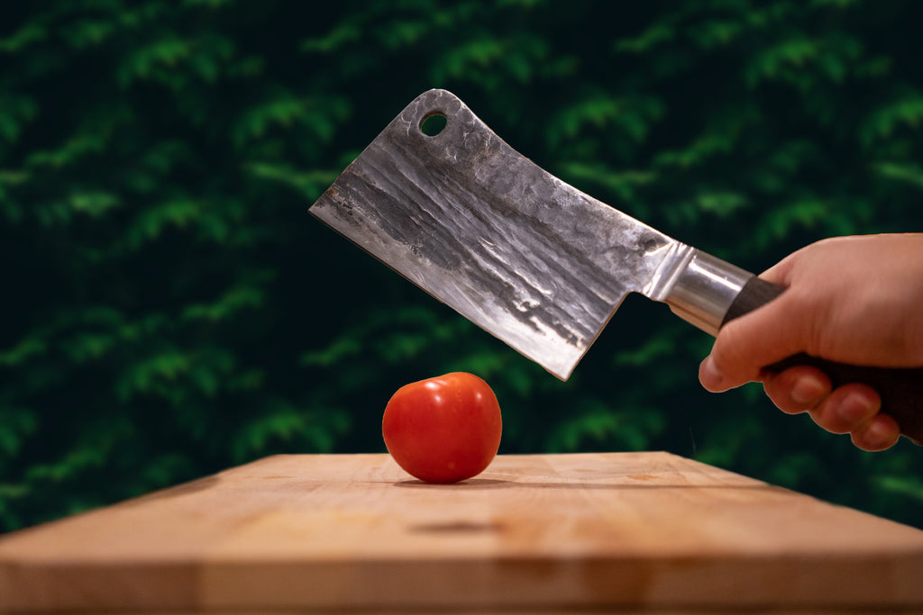Cleaver cutting tomato