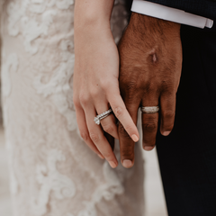 Man and woman's hand in a wedding photo on their wedding day with wedding rings on.