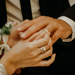 Man and woman exchanging wedding bands at a wedding.