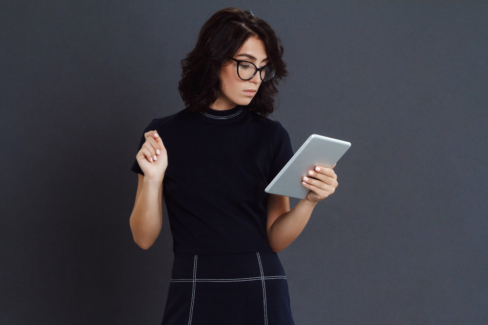 beautiful-young-woman-wearing-glasses-posing-grey-wall-holding-tablet-hands.jpg__PID:c864fa22-fd35-4b8d-bd9b-d50bd36b2be1