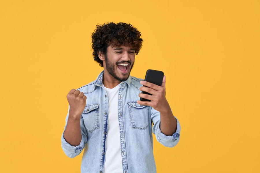 Young man looking at his phone with excited expression