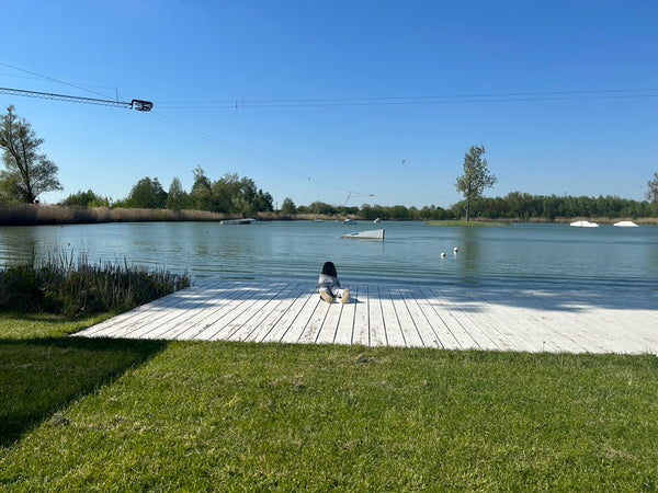 Little girl lying on the bank of a pond.