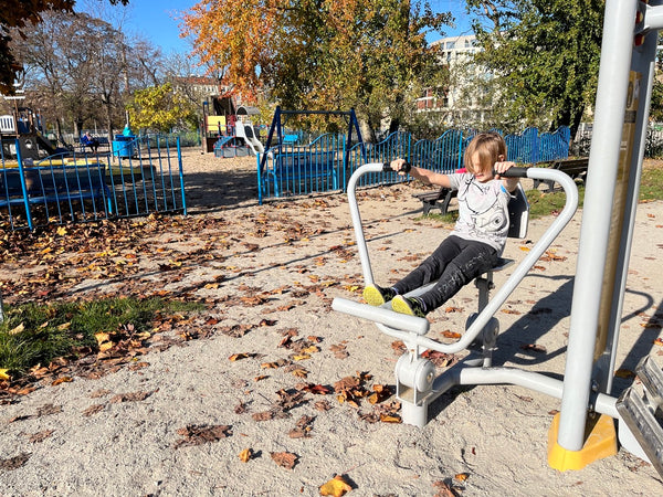 Happy child playing in an outdoor gym in the park.