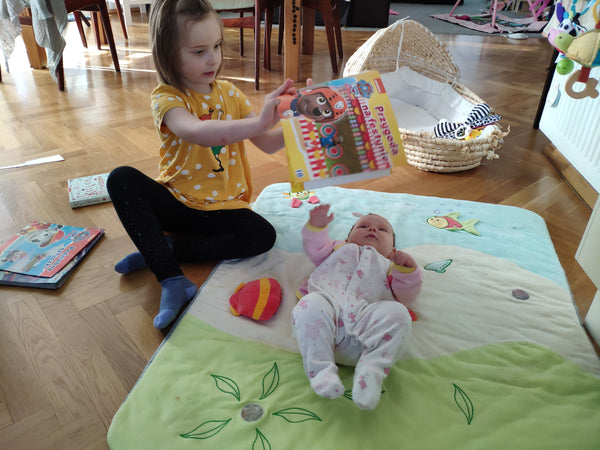 Little sisters reading a book. 