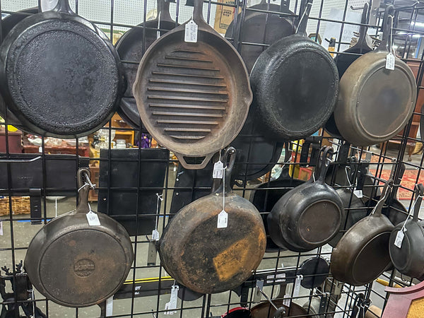cast iron pans hanging on a wire wall