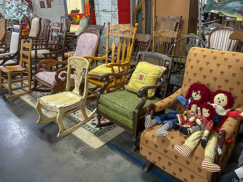 array of rocking chairs with one holding vintage Raggedy Anne & Raggedy Andy dolls