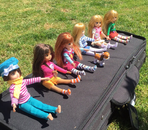 bunch of lottie dolls sitting on a violin case