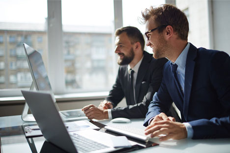 Two office staff having a discussion in front of computer