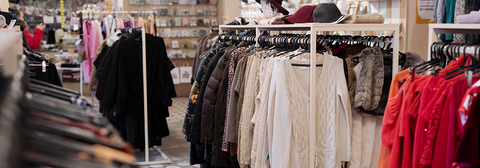 Racks of clothing in a thrift shop.