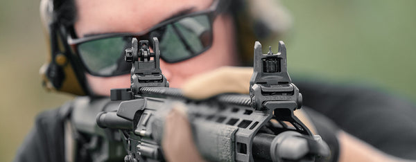 Shooter in Magpul Eyewear aiming with a set of MBUS 3 Sights on an AR15