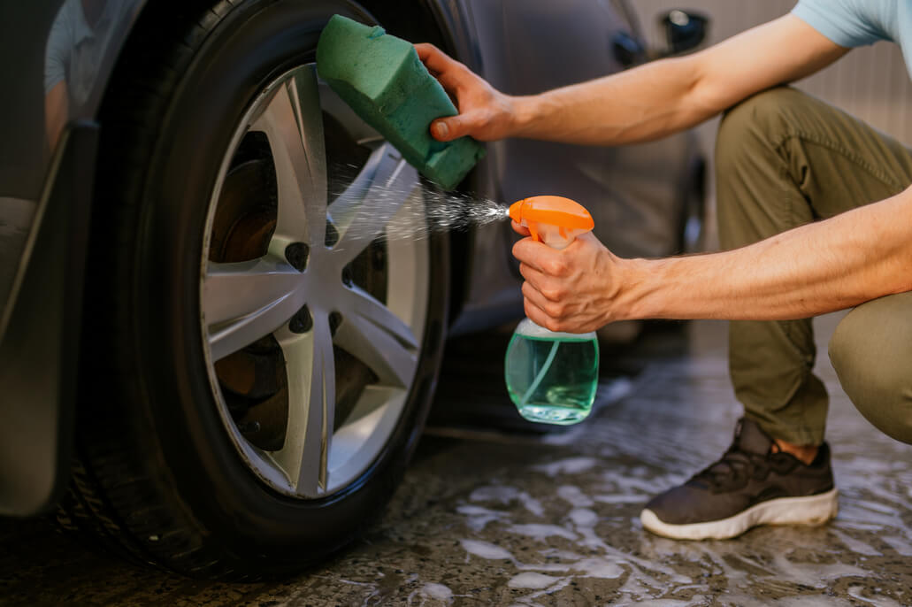 man showing how to clean car wheels