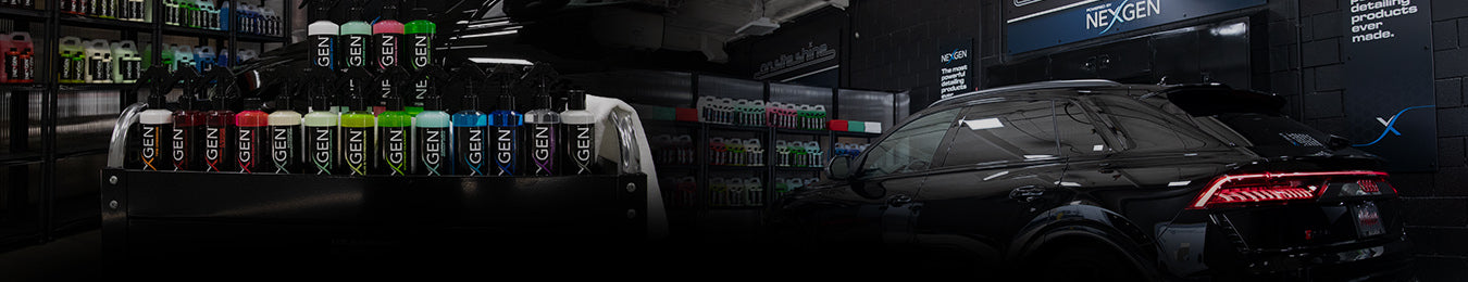 Car detailing products on shelves beside a glossy black car in a garage.