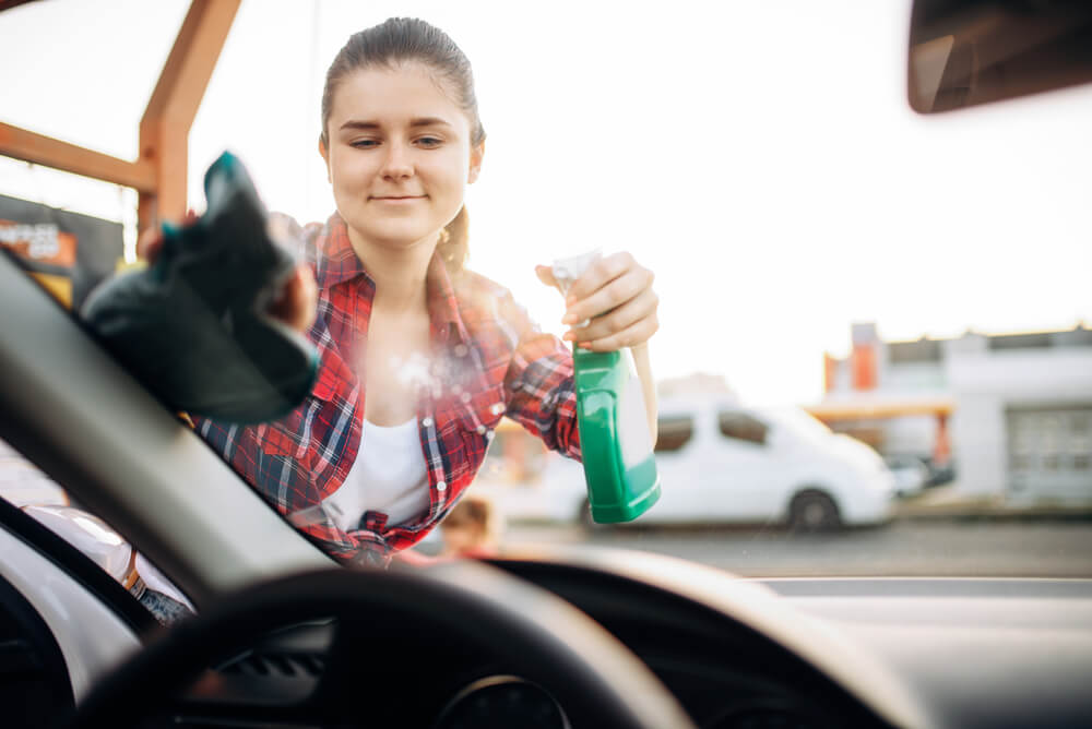 woman applying the best way to clean a windshield