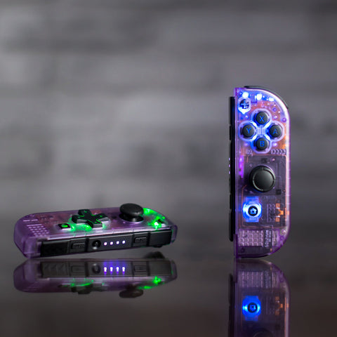 Joy-Cons de color violeta atómico transparente con botones retroiluminados por LED negros.