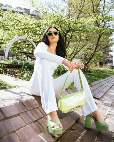 My Accessories London. Garden party collection style advice . Green sequin shoulder bag, green oval chunky sunglasses with green satin bandana head scarf top and chunky green shoes 