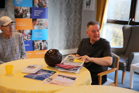 Sporting Memories - 2 club members at table with old football