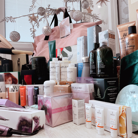 large collection of beauty products in front of a christmas tree