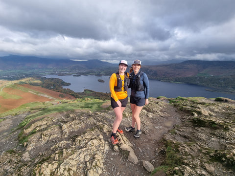 Two runners on the summit of Catbells
