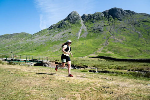 Female runner taking part in a trail running race in the Lake District mountains