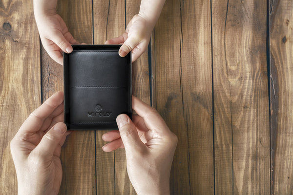 the best father's day gift - a girl's hands giving her father a wallet