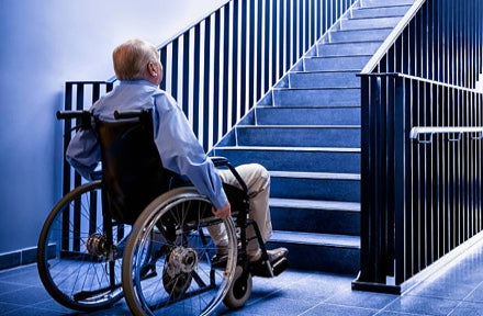 person in a wheelchair in front of a flight of stairs