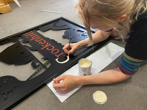 Hand painting text on a village sign